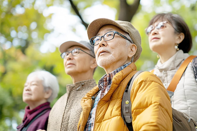 シニア4人が自然の中を歩いている様子